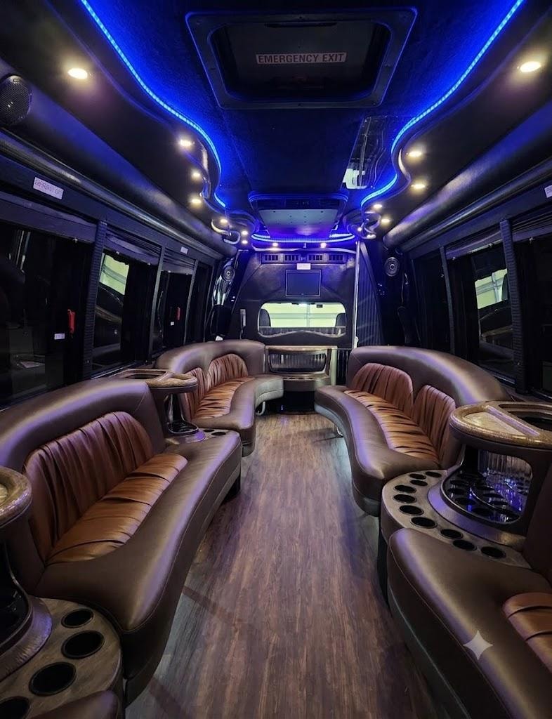 Vegas Limo Bus interior — brown leather curved seating with hardwood floor and blue neon ceiling lighting