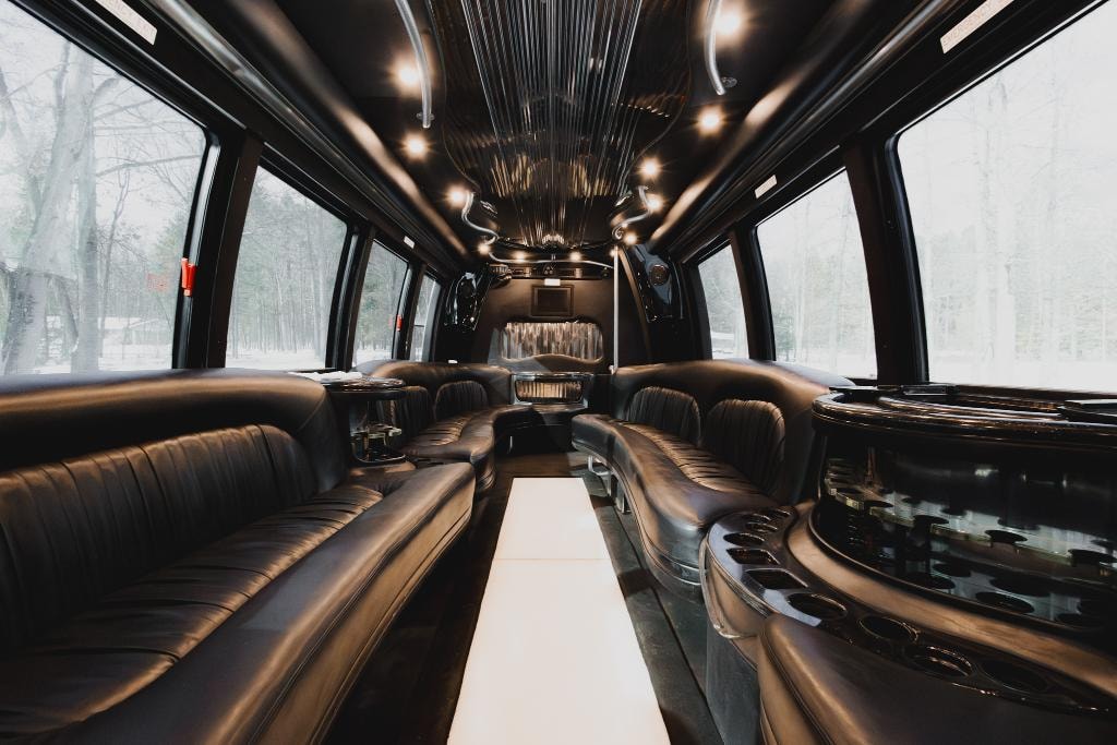 Vegas Limo Bus interior — black leather seating with illuminated floor and panoramic windows