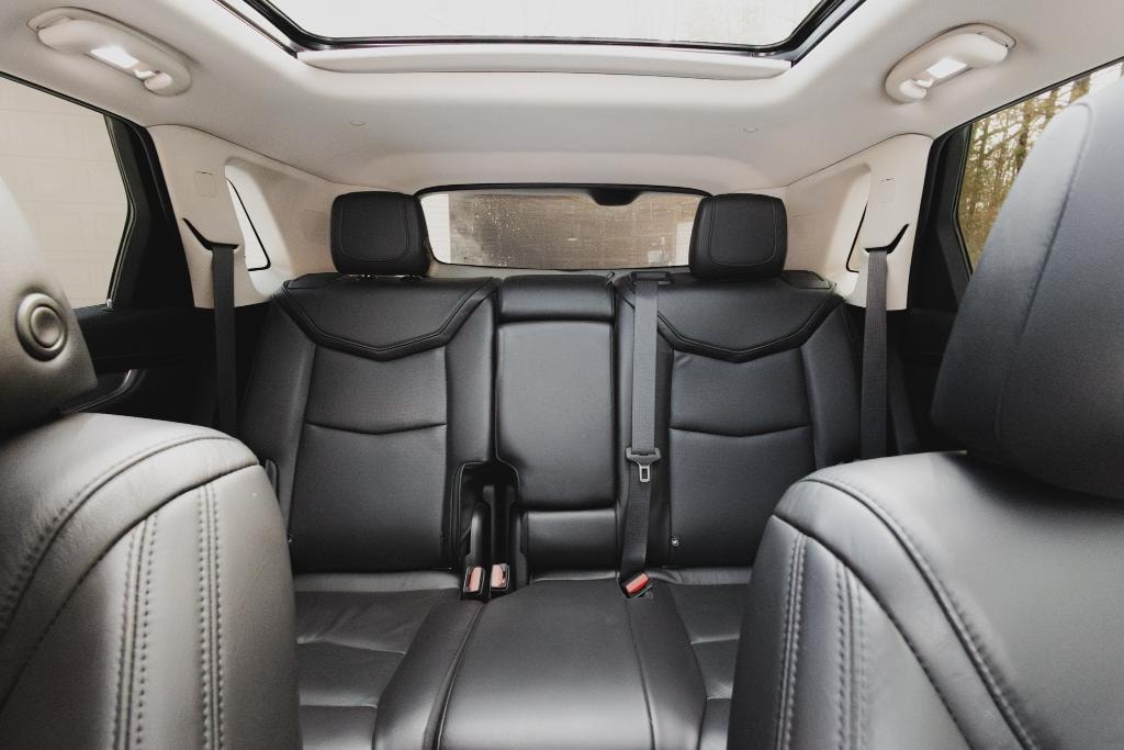 Cadillac XT5 interior — black leather rear seating with panoramic sunroof