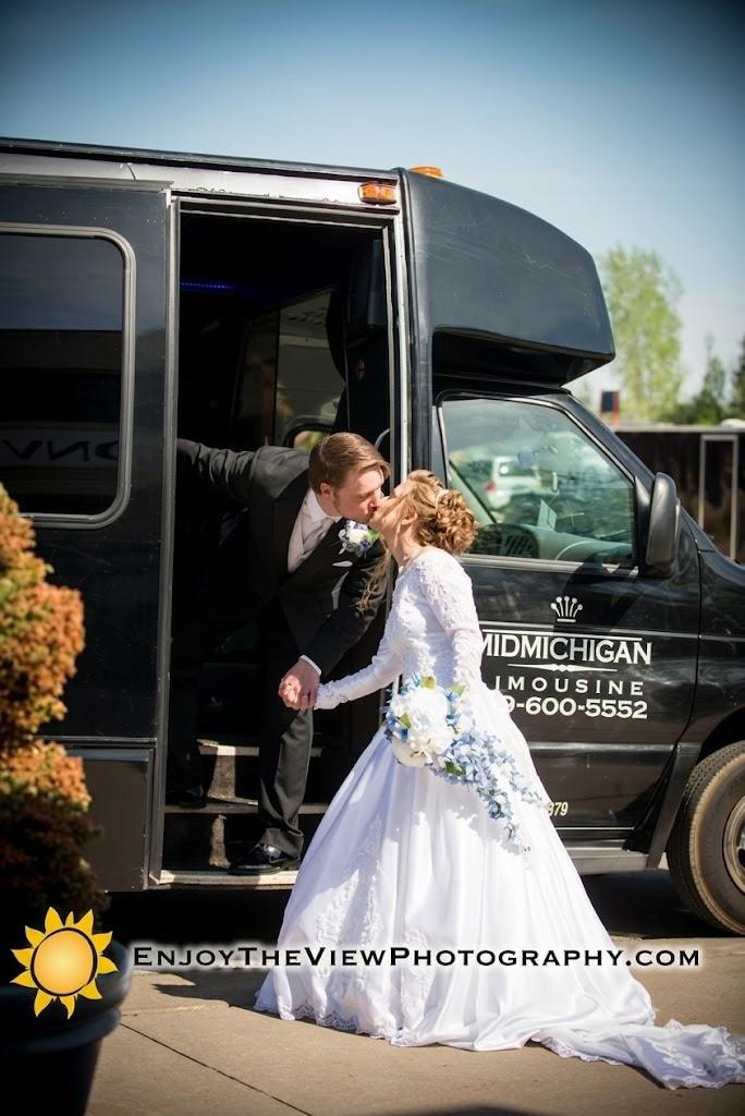 Bride and groom kissing at the door of Mid Michigan Limousine party bus