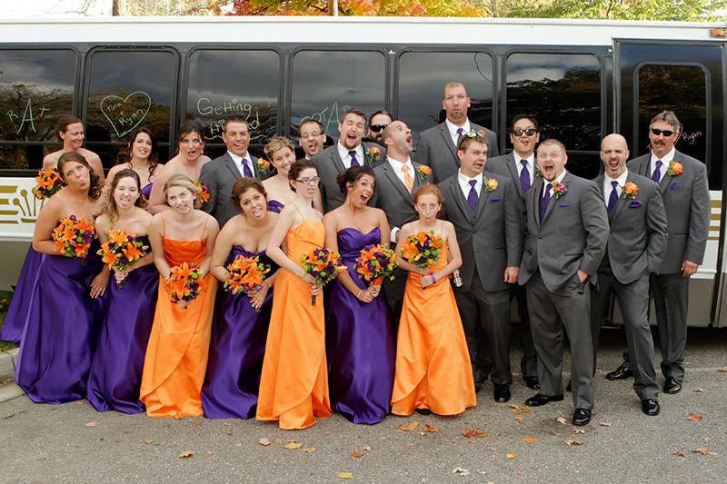 Wedding party group photo in front of Mid Michigan Limousine party bus